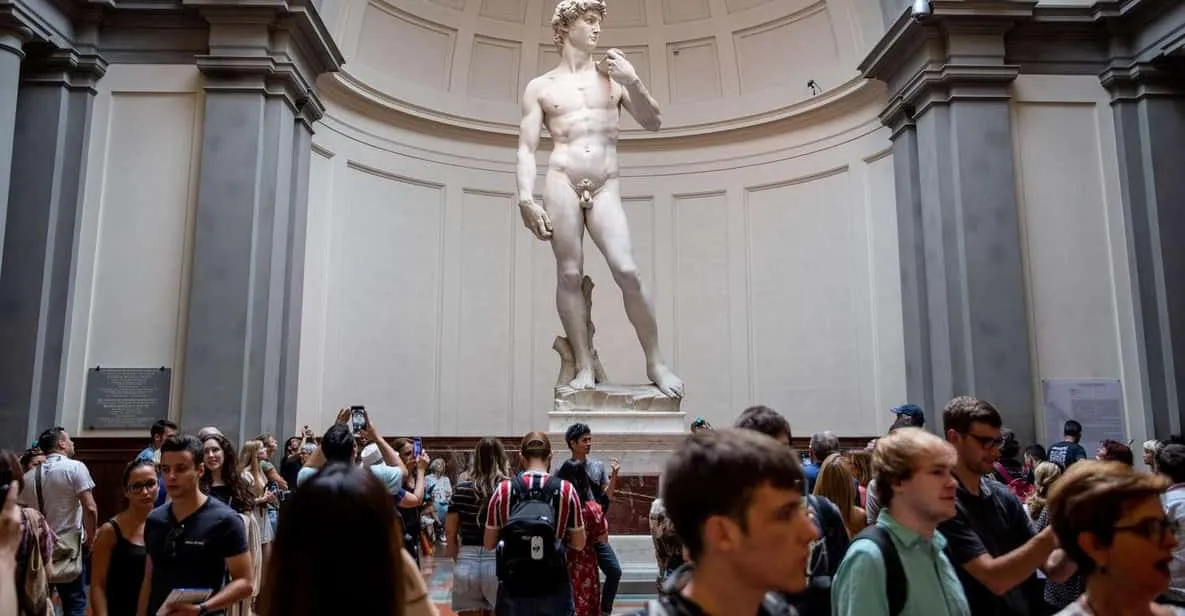 Visitors walking the Accademia Gallery toward Michelangelo's David in Florence, Italy