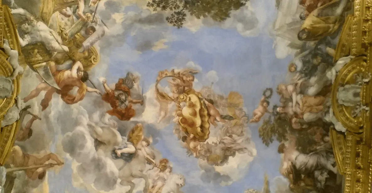 Paintings stacked on silk walls in the Palatina Gallery at Pitti Palace, a museum in Florence, Italy